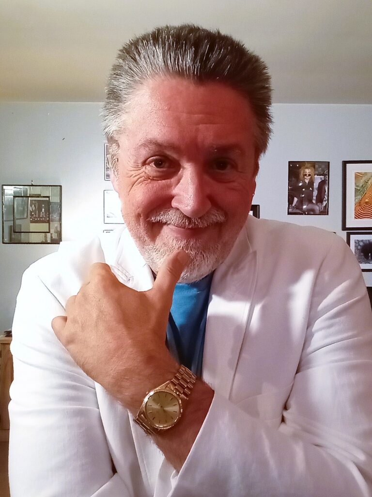 Pat green in white suit and gold watch