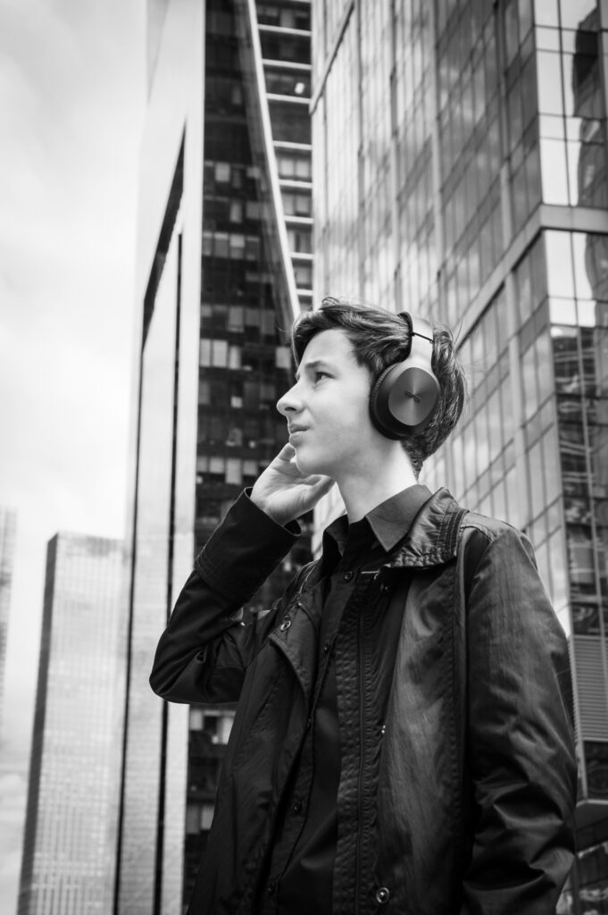 teenager in city listening to headphones