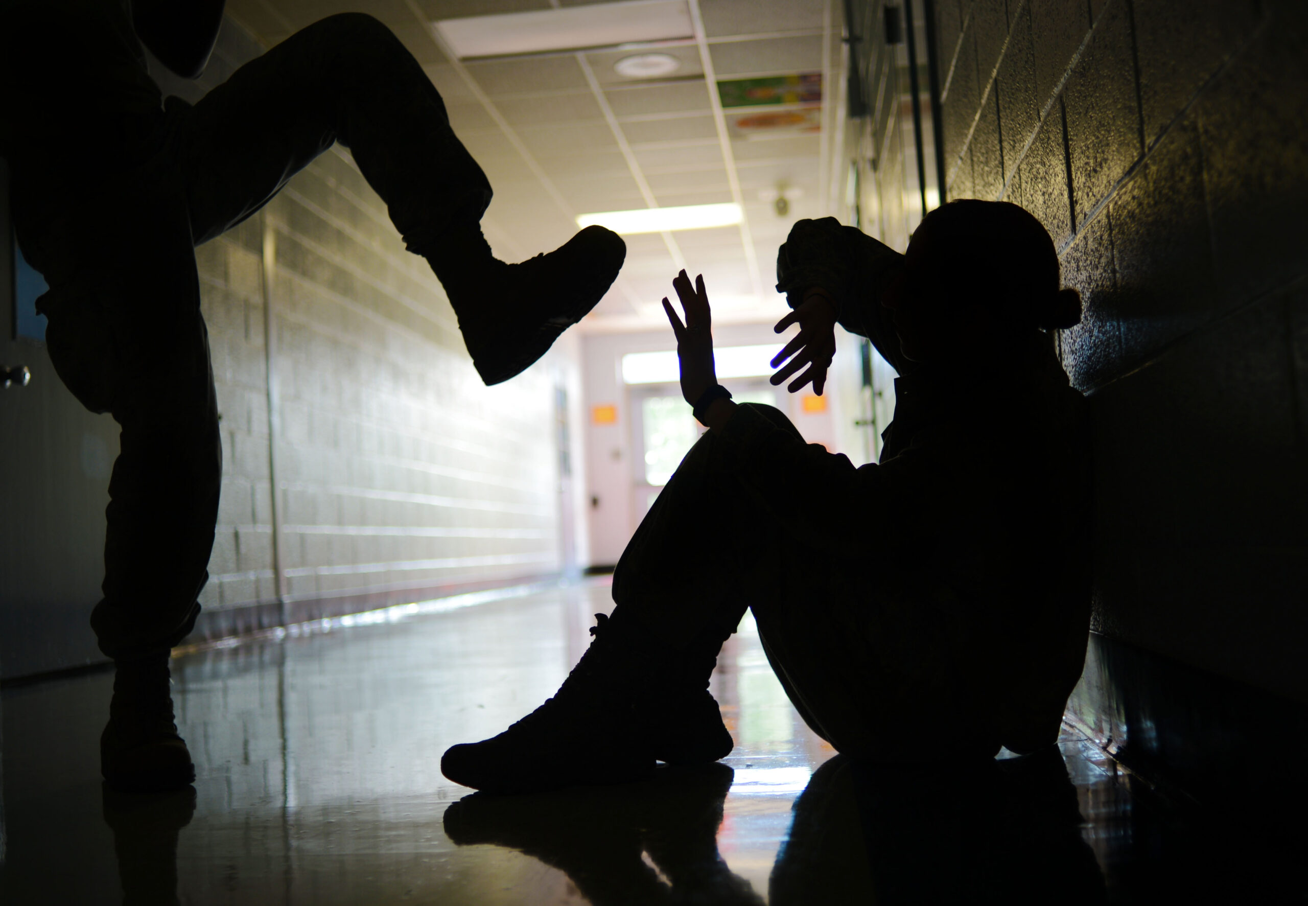 Person on ground about to be kicked by person standing above them