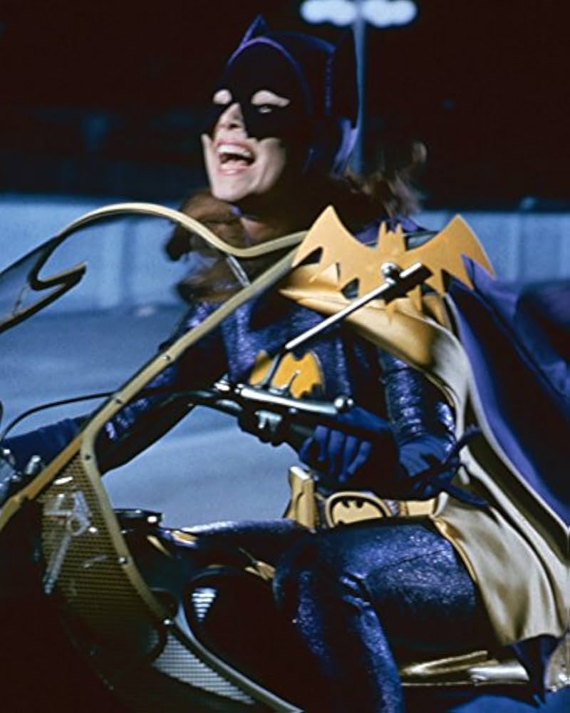 yvonne craig as batgirl riding her motorcycle while smiling