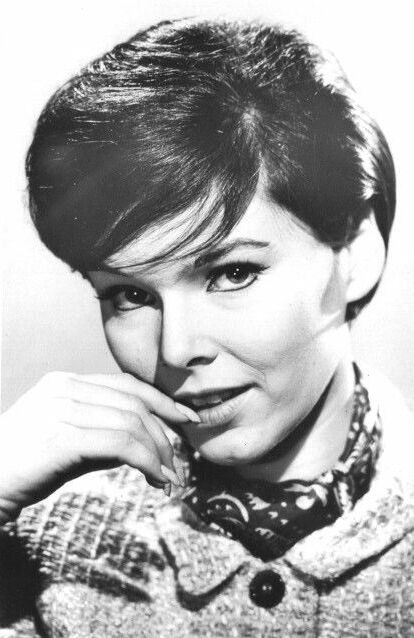 yvonne craig with short hair and finger to lips with slight smile