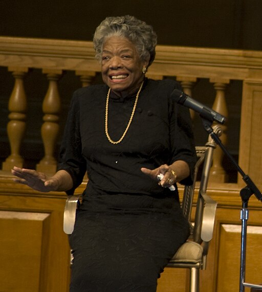 Maya Angelou in a black dress smiling.