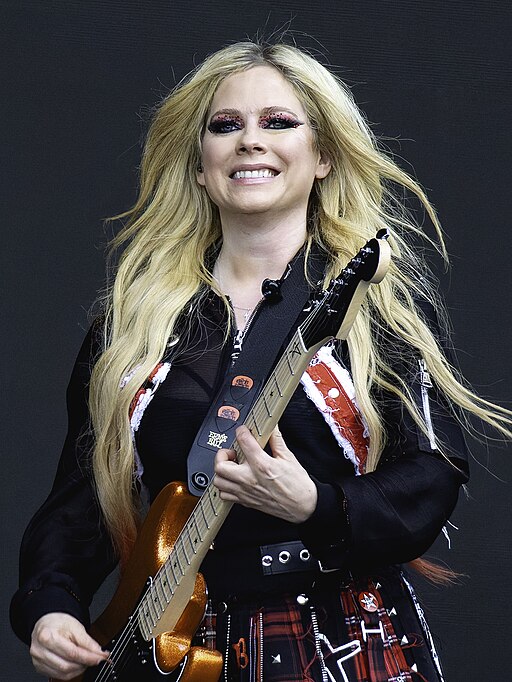 Blonde woman smiling while holding electric guitar