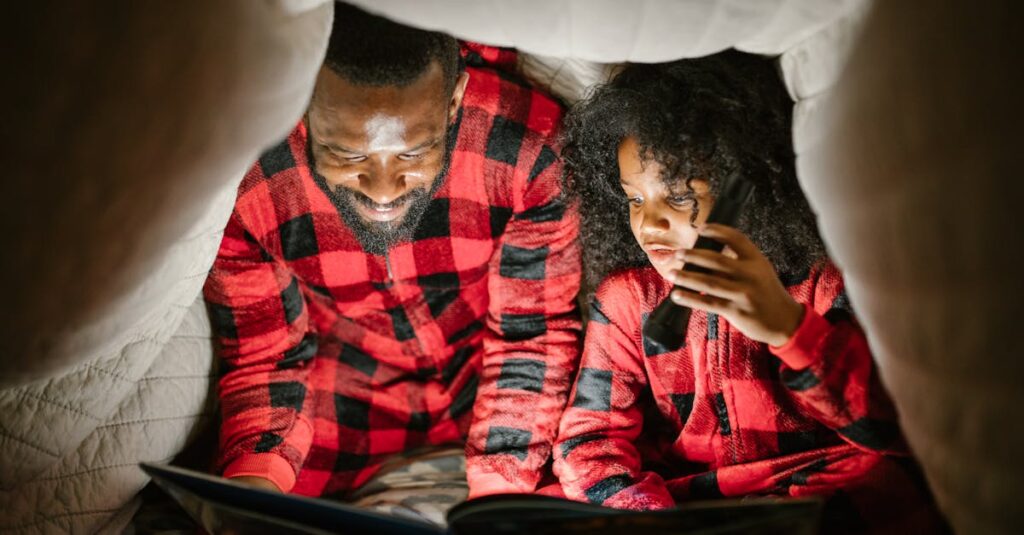 Father and Child Reading to Flashlight under Blanket