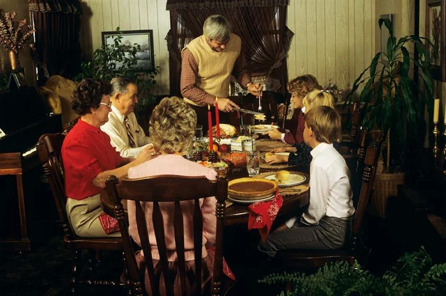 A family in the 1980s sitting over a thansgiving table.