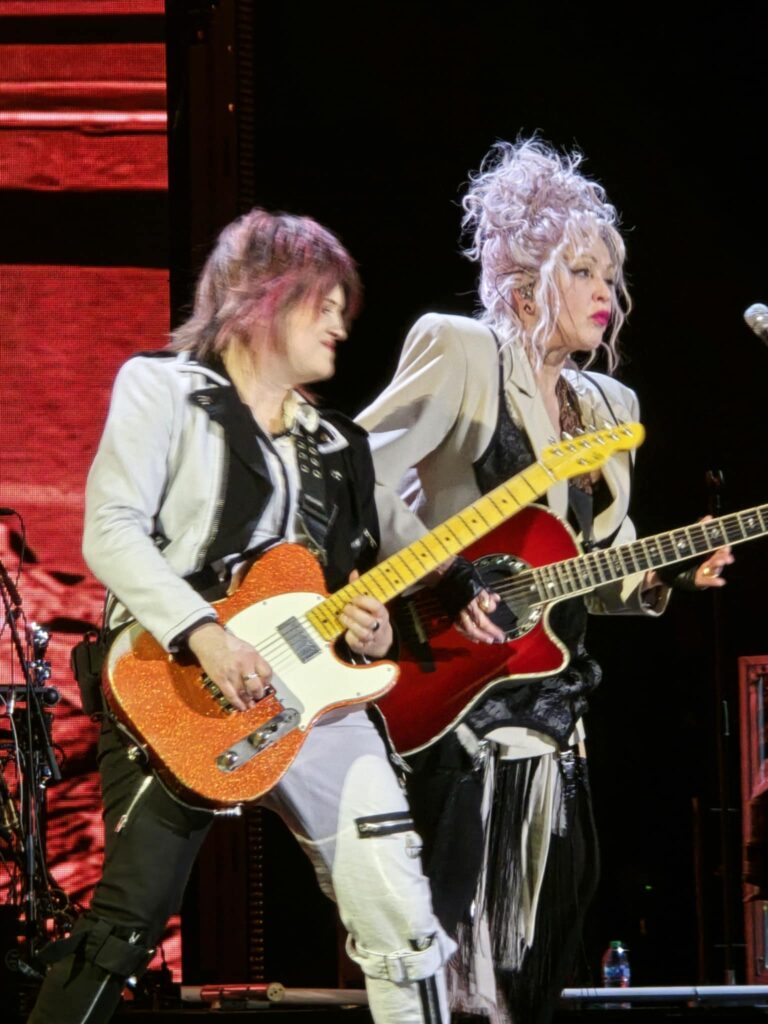 Cyndi Lauper and backup guitarist both with guitars on stage