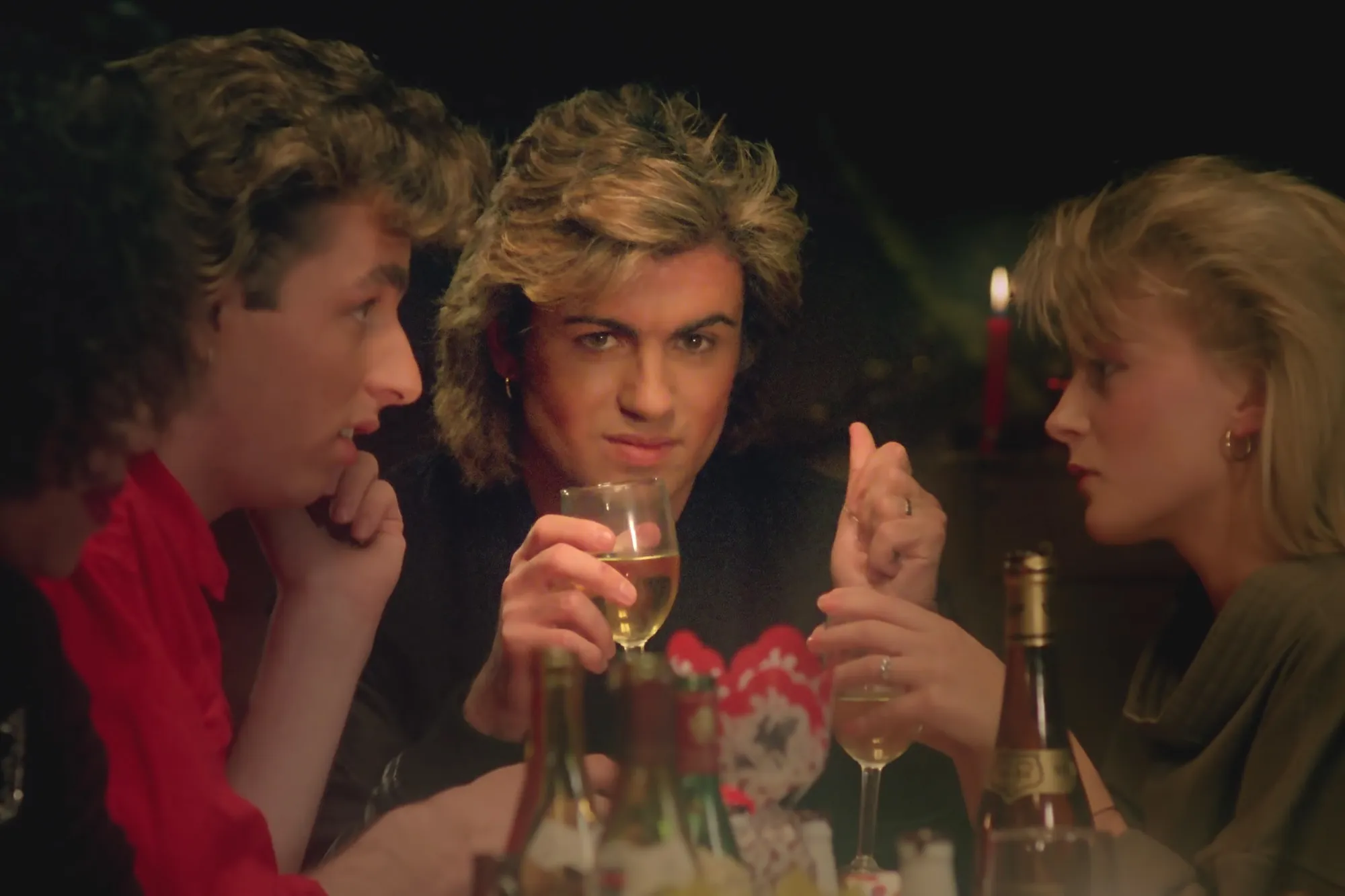 George Michael at a Christmas table looking into the camera.