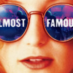 Close up of blonde woman with large sunglasses. Words on the lenses read Almost Famous.