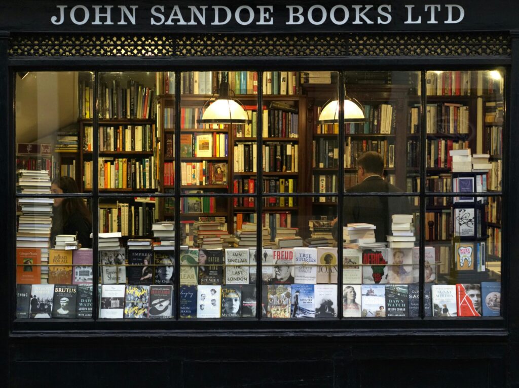 A cozy London bookstore showcasing various books through a classic window display.